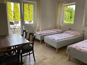 een kamer met 4 bedden en een tafel en stoelen bij Willa Bursztynowa 1 - pokoje gościnne in Rekowo