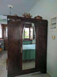 an old wooden cabinet with a mirror in a room at Ξενώνας Μυρτώ in Andritsaina