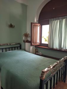 a bedroom with a green bed with a window at Ξενώνας Μυρτώ in Andritsaina