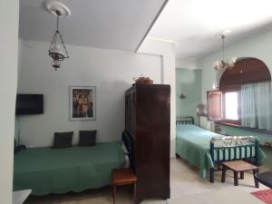 a bedroom with two green beds and a window at Ξενώνας Μυρτώ in Andritsaina +11 photos
