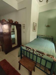 a bedroom with a bed and a mirror and a stool at Ξενώνας Μυρτώ in Andritsaina