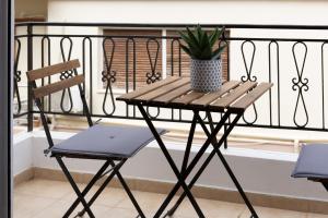 a table and chair on a balcony with a potted plant at Bizaniou Central Apt - Heraklion Crete in Bendevís