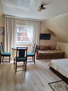 a bedroom with a bed and a table and chairs at Augutės Zurlienės apartamentai in Trakai