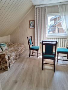 a bedroom with a bed and two chairs and a table at Augutės Zurlienės apartamentai in Trakai