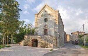 una antigua iglesia de piedra con un gran edificio en Casa Vicolo Lugnano, en Città di Castello