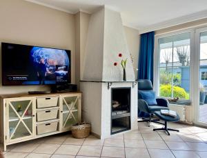 ein Wohnzimmer mit einem Kamin und einem TV in der Unterkunft Haus Strandmuschel in Büsum