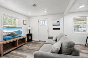 a living room with a couch and a flat screen tv at Peach Street Super Suite in Medford