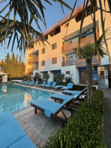 a hotel with a swimming pool with lounge chairs at Hotel Athina in Velipojë