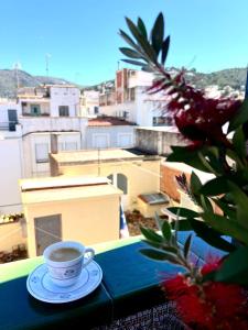 a cup of coffee sitting on a table with a view at Escondite central con terraza compartida en la azotea in Roses