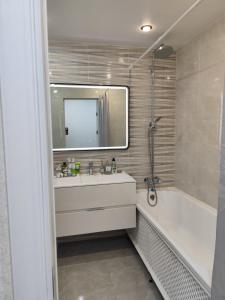 a bathroom with a tub and a sink and a mirror at Квартира Ауэзова 102 Щучинск in Shchūchīnsk