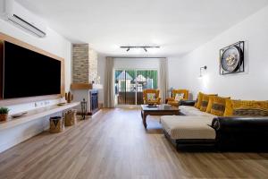 a living room with a couch and a tv at Villa For Families los Agaves in La Cala de Mijas