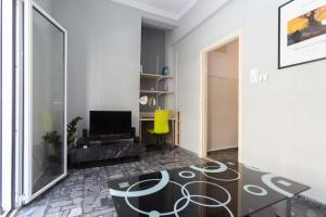 a living room with a table and a yellow chair at Bizaniou Central Apt - Heraklion Crete in Bendevís