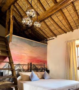 a bedroom with a bed and a painting on the wall at Hotel Anticos Palathos in Orosei