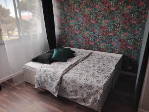 a bedroom with a bed with a floral wallpaper at studio hyeres port et iles d'or. in Hyères