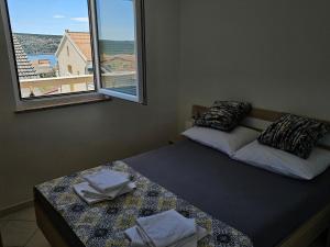 a bedroom with two beds and a window with a view at Apartments Cimbal in Stara Novalja
