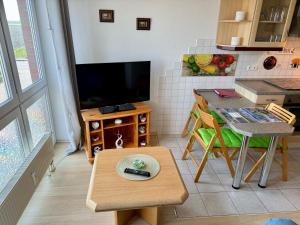a living room with a television and a table with a remote control at Apartement Seeblick in Nordstrand