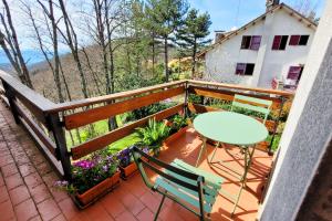 a balcony with a table and chairs and flowers at Homestay in Tuscan countryside with private bathroom and terrace in Borselli