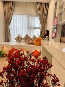 a woman sitting in a room looking out the window at Resort ori , S10 03 luxury Vinhomes Grand pard in Long Bình