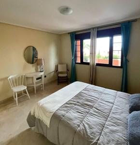een slaapkamer met een bed, een bureau en een raam bij El Mirador del Golf Marbella 3 bedroom apartment in Ojén