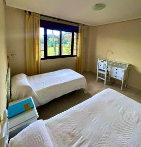 een slaapkamer met 2 bedden en een raam bij El Mirador del Golf Marbella 3 bedroom apartment in Ojén