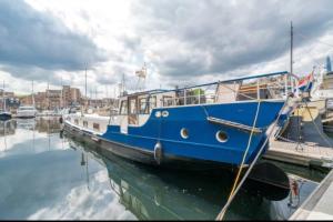 um barco azul e branco ancorado numa doca em Historic Dutch Barge, Idyllic location em Londres