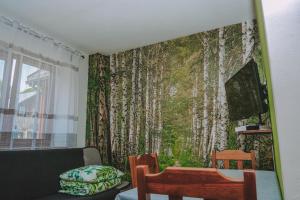 una sala de estar con un mural de árboles en la pared en Noclegi nad Zalewem Bukówka, en Lubawka