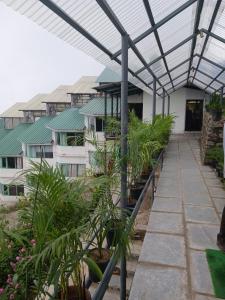 ein Gewächshaus mit Pflanzen an der Seite eines Gebäudes in der Unterkunft Kufri Holiday Resort in Kūfrī