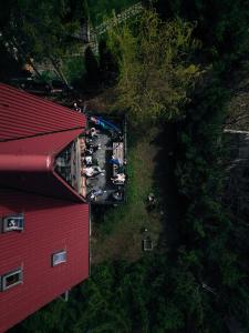 une vue de tête d'un bâtiment rouge à côté d'un arbre dans l'établissement Acasa La Munte, à Azuga