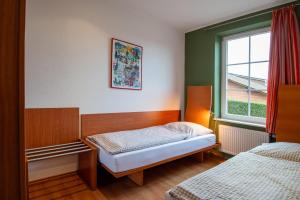 Habitación pequeña con 2 camas y ventana en Glockenhof Studtmann en Amelinghausen