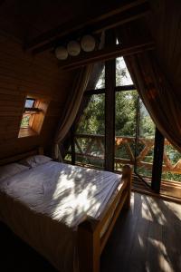 a bedroom with a bed in front of a window at Acasa La Munte in Azuga
