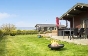 a backyard with a fire pit in the grass at Cozy Home In Bogense With Wifi in Bogense +10 photos