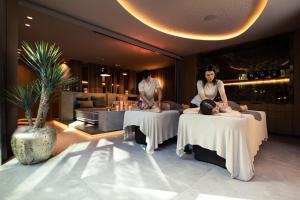 een groep mensen die op tafels in een kamer zitten bij Quellenhof Luxury Resort Lazise in Lazise