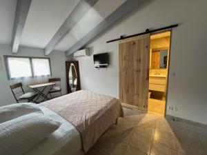 a bedroom with a bed and a desk and a table at Auberge du col saint Georges in Grosseto-Prugna