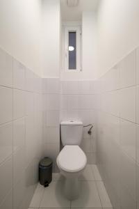 a white bathroom with a toilet and a window at Racoczy 5BR 3BR Cozy Getaway in Budapest