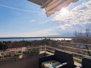 a balcony with a couch and an umbrella at Apartment Felix in Rijeka