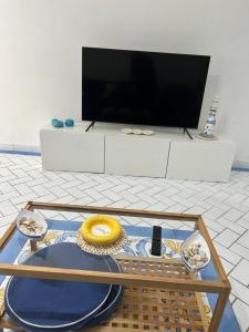 sala de estar con TV y mesa en Nanà casa vacanza en Capri