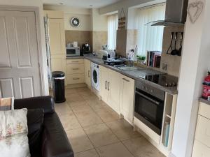 a kitchen with a sink and a stove top oven at Woodside Cottage Grewelthorpe Nr Masham in Grewelthorpe