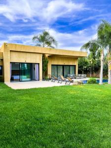 una casa con un césped verde delante de ella en Villa Khmissa 5, en Marrakech