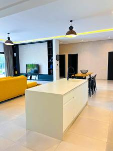 cocina y sala de estar con sofá amarillo en Villa Khmissa 5, en Marrakech