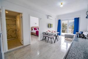 a living room with a table and chairs and a bedroom at Gökkuşağı Pansiyon in Kaş