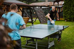 dos hombres jugando ping pong en una mesa de ping pong en Apartmány Velké Karlovice, en Vsetín