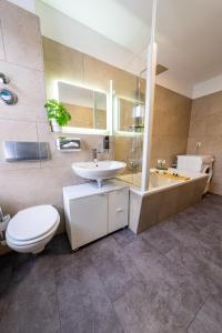 y baño con lavabo, aseo y bañera. en Luxury Vista Apartment I Küche I WLAN I Smart-TV, en Magdeburgo