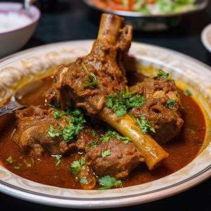 a plate of food with meat and gravy at J Hotel and Banquets in Mumbai