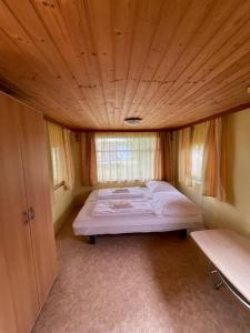 een bed in een kamer met een houten plafond bij Tiny Hous 2 Erwachsene 2 Kinder in Ferlach