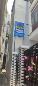 un cartello sul lato di un edificio con fiori rosa di Suri's Homestay a Quy Nhon