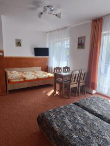 a bedroom with a table and chairs and a bed at Gabi in Jastrzębia Góra
