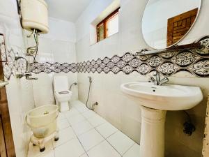 uma casa de banho com um lavatório, um WC e um espelho. em Hotel Sliver Inn - Affordable Luxury Stay Near Mall Road em Manali