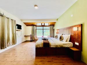 1 dormitorio con cama grande y ventana grande en Hotel Sliver Inn - Affordable Luxury Stay Near Mall Road, en Manali