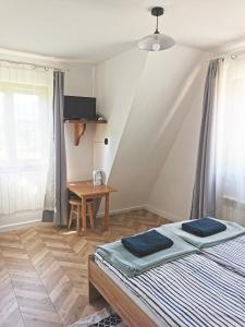 Schlafzimmer mit einem Bett, einem Tisch und einem Schreibtisch in der Unterkunft Czarny Jeleń in Zakopane