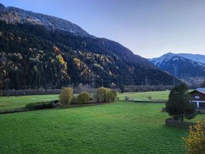 a green field with a house and a mountain at Ferienwohnung in perfekter Lage in der Surselva in Trun